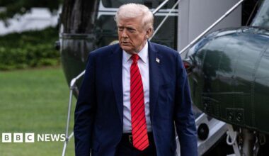 Donald Trump walks away from a helicopter wearing a suit and red tie after he returns to the White House following a visit to Walter Reed National Military Medical Center on 10 October 2025.