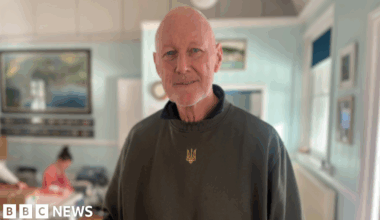 The photo shows David Pond smiling at the camera wearing a green jumper.