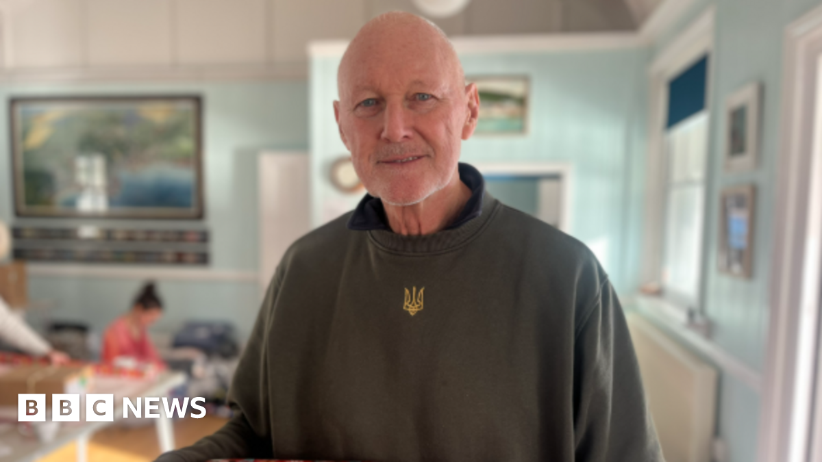 The photo shows David Pond smiling at the camera wearing a green jumper.