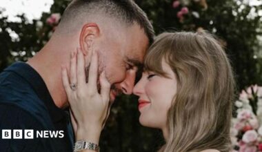 Susanna Liew, wearing a white top with black polka dots, is seated on a brown sofa and looking straight at the camera