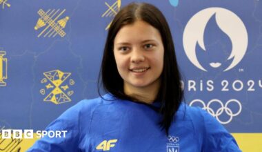 Ukrainian diver Sofiia Lyskun holds a national flag during the welcome ceremony at the Central Railway Terminal upon her return from the Paris 2024 Olympics