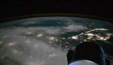 a lights from cities along the coast of a peninsula are seen at night from space