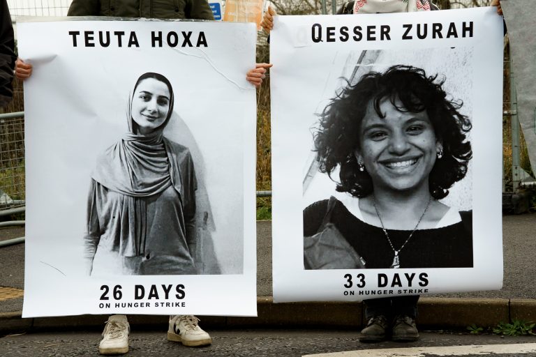 Large white banners showing the smiling faces of two women