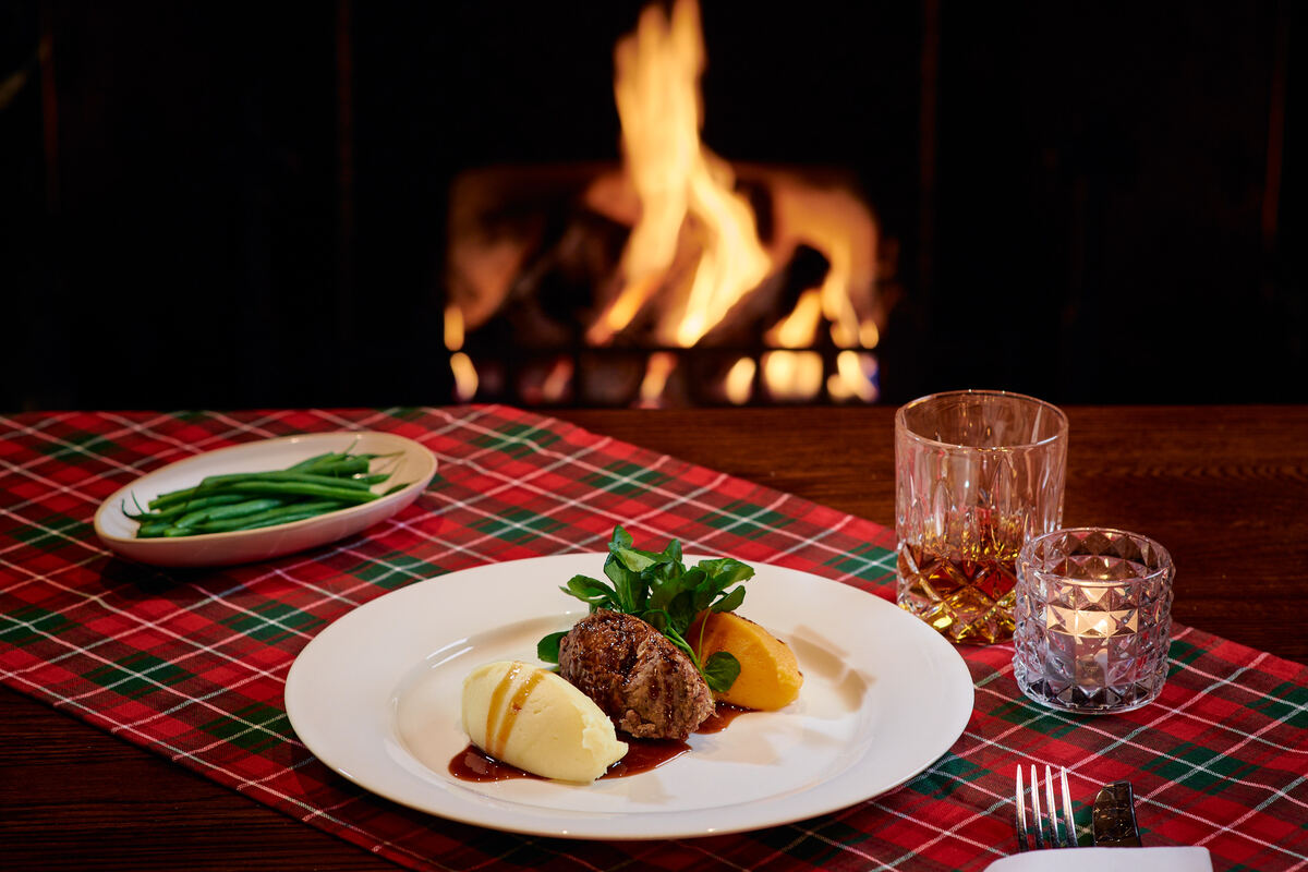 a platter of special burns night scottish food in front of a roaring fire