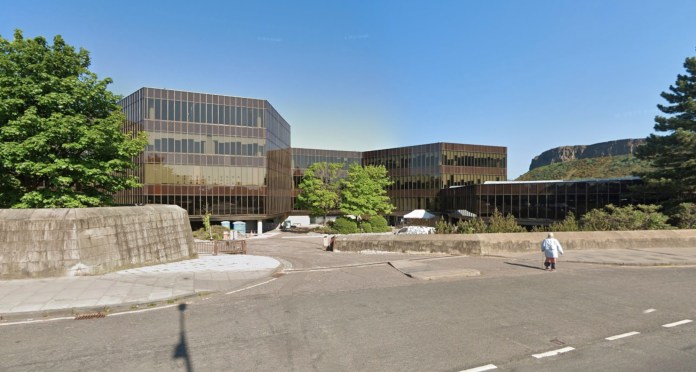 glass buildings with cliff in background