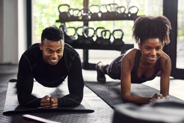 Two people planking in the gym
