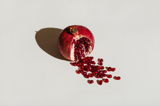 ut pomegranate on a white background. Menstruation concept. Symbol of vagina. Gynecology, female intimate health