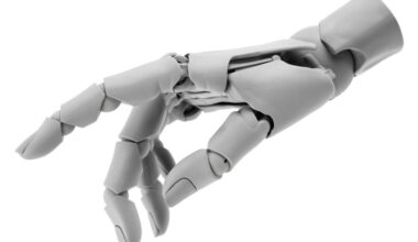 Image of a white plastic robotic hand against a white backdrop.