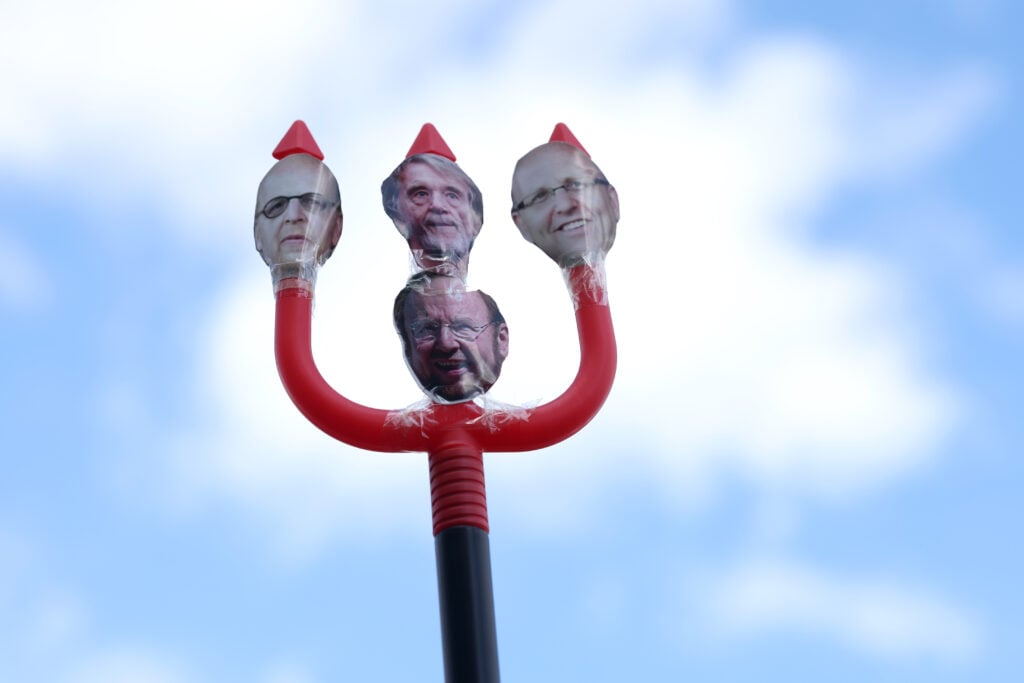 A detailed view of a devil's fork featuring the faces Manchester United owners Avram Glazer, Jim Ratcliffe, Joel Glazer and Malcolm Glazer as fans protest outside the stadium prior to the Premier League match between Manchester United FC and Aston Villa FC at Old Trafford on May 25, 2025
