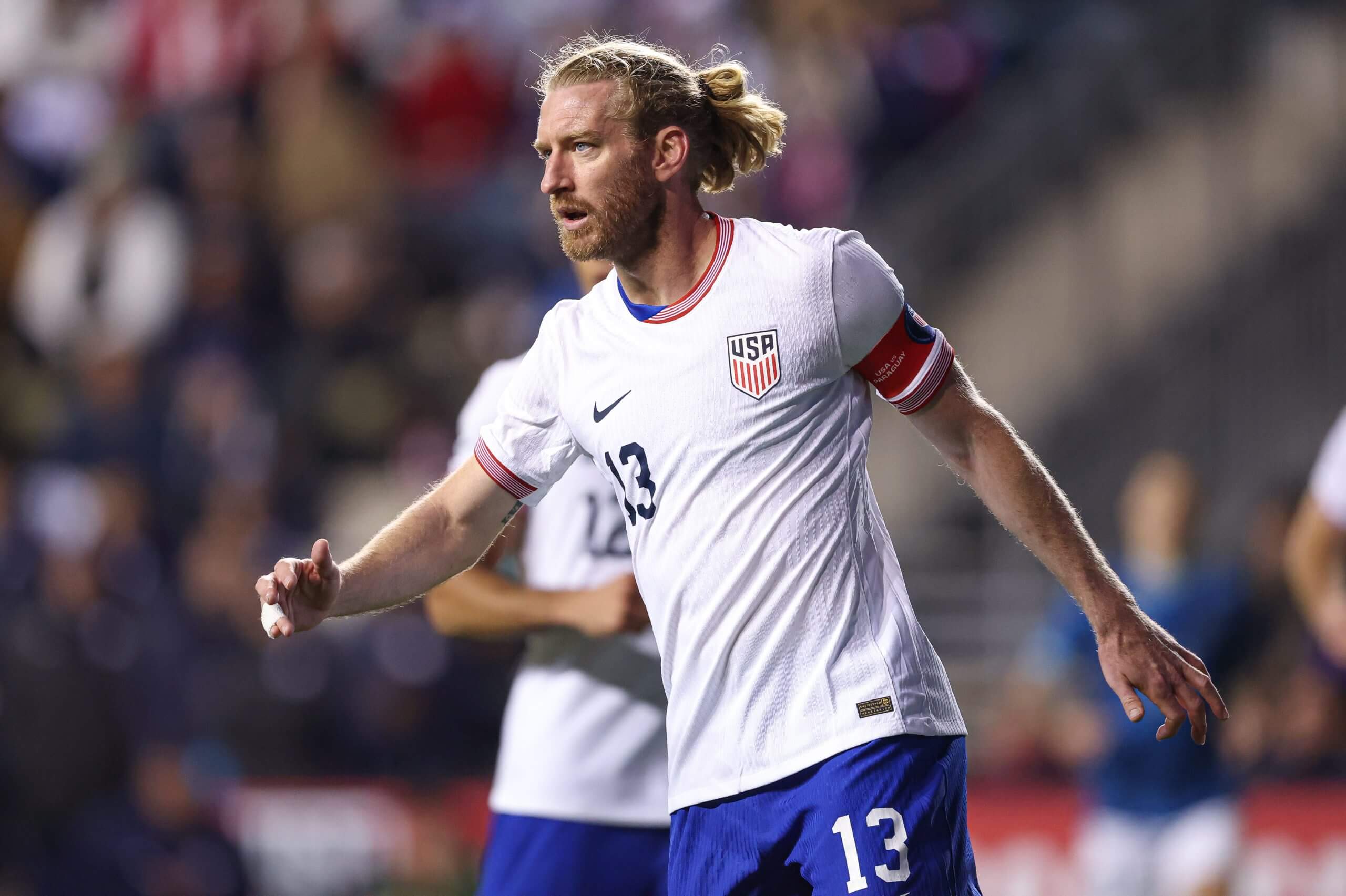 Tim Ream, wearing No. 13 on his jersey, watches the field mid stride.