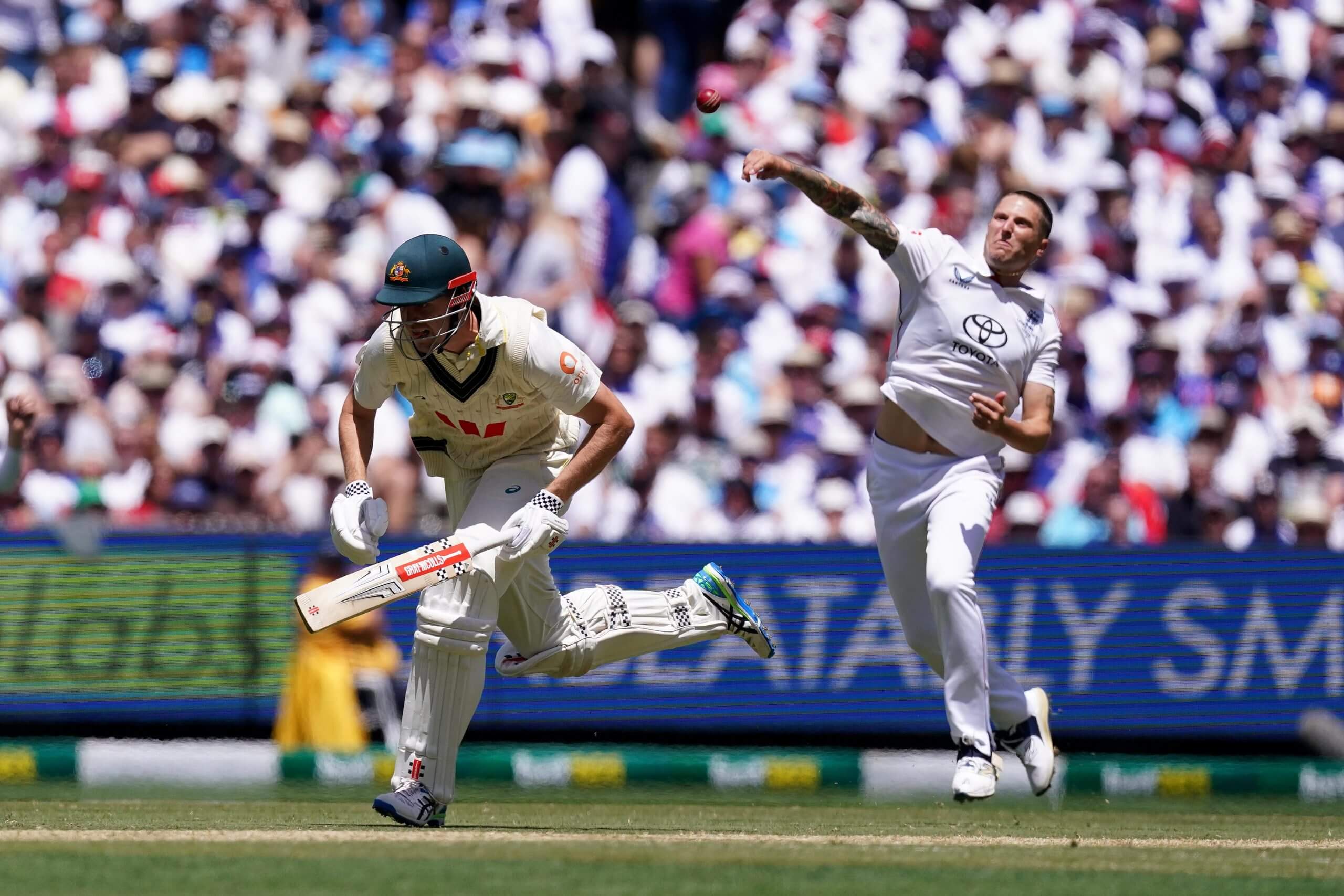 Brydon Carse flings the ball towards the stumps at the bowler's end as Cameron Green fears the worst
