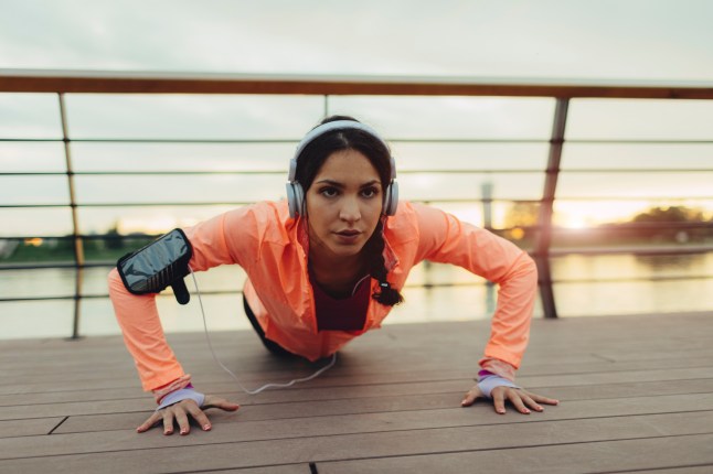 Woman doing a push-up by the riverside.