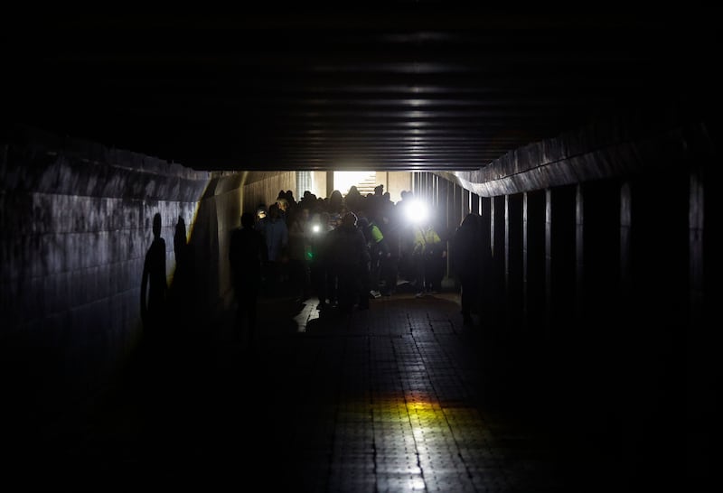 A group of children walks with flashlights in the dark underground crossing during the electricity cut-off in downtown Kyiv, Ukraine. Photograph: EPA
