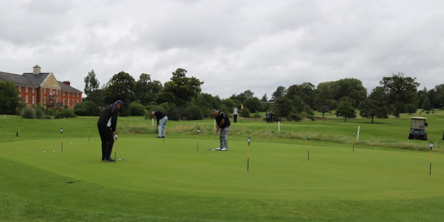 Golfes on the golf course putting green