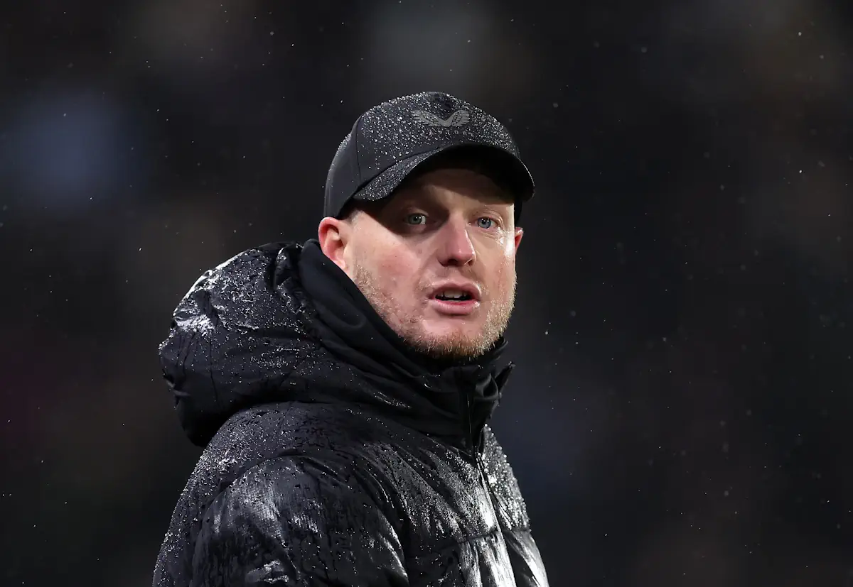 Middlesbrough manager Kim Hellberg looks on during a game wearing a baseball cap and big coat