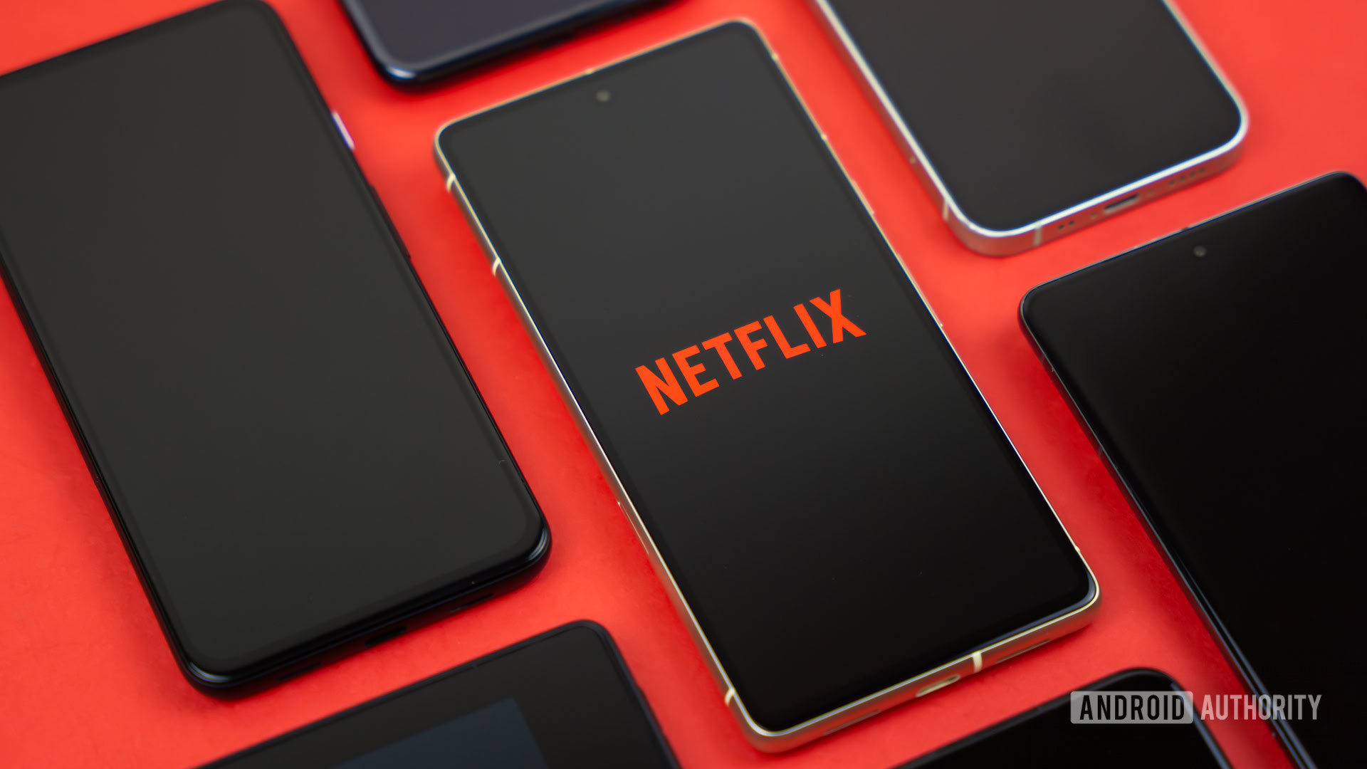 Netflix logo on smartphone, next to other devices stock photo (1) Netflix logo on smartphone, next to other devices stock photo (1)