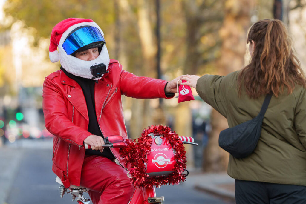 HARVEYRIDESBIKES HANDING OUT GIFTS TO STRANGERS ON RED SANTANDER BIKE
