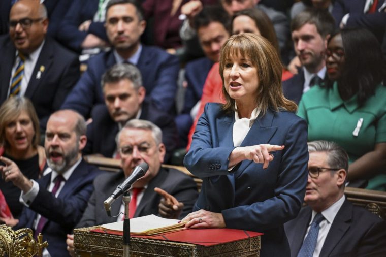This handout photograph taken and released by the UK Parliament's House of Commons on November 26, 2025 shows Britain's Chancellor of the Exchequer Rachel Reeves (R) speaking in the House of Commons in London as the government delivered its annual budget. Britain's Labour government unveiled a tax-raising budget on November 26 costing billions of pounds to curb debt and fund public services, as the country faces lower economic growth in the coming years. (Photo by Handout / House of Commons / AFP via Getty Images) / RESTRICTED TO EDITORIAL USE - MANDATORY CREDIT " AFP PHOTO / House of Commons " - NO USE FOR ENTERTAINMENT, SATIRICAL, MARKETING OR ADVERTISING CAMPAIGNS - EDITORS NOTE THE IMAGE MAY HAVE BEEN DIGITALLY ALTERED AT SOURCE TO OBSCURE VISIBLE DOCUMENTS - BEST QUALITY AVAILABLE /