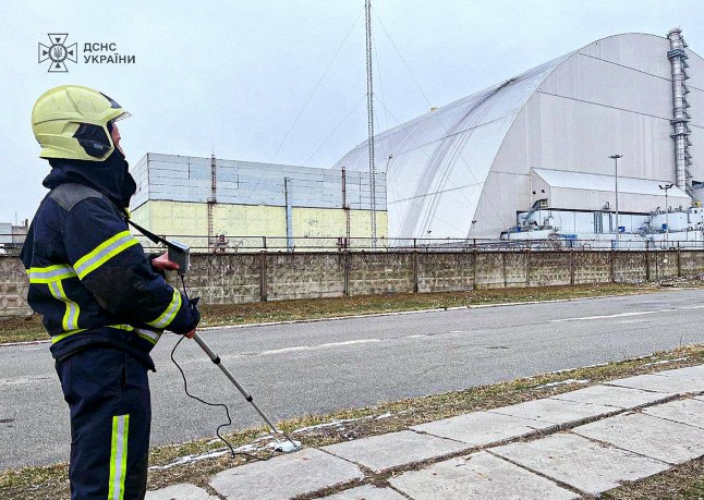 (FILES) This handout photograph taken and released by Ukrainian Emergency Service on February 14, 2025 shows an employee working outside the New Safe Confinement (NSC), which protects the remains of reactor 4 of the former Chernobyl Nuclear Power Plant following a drone attack on its cover built to contain radiation. The International Atomic Energy Agency (IAEA) announced on December 7, 2025 that its teams had been in Ukraine since early December to assess nuclear safety and had found that the Chernobyl arch had lost its
