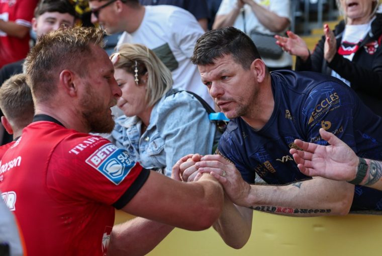 HULL, ENGLAND - AUGUST 10: Salford Red Devils' Brad Dwyer shakes hands with a fan after the match during the Betfred Super League Round 21 match between Hull FC and Salford Red Devils at MKM Stadium on August 10, 2025 in Hull, England. (Photo by Lee Parker - CameraSport via Getty Images)