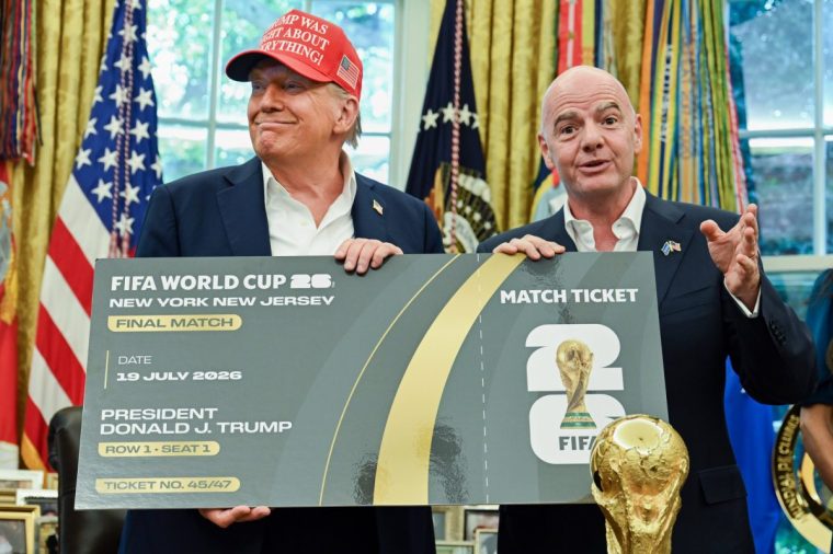 US President Donald Trump, left, and Gianni Infantino, president of the Federation International Football Association (FIFA), hold a ticket to the final 2026 FIFA World Cup match in the Oval Office of the White House in Washington, DC, US, on Friday, Aug. 22, 2025. Trump announced that Washington's John F. Kennedy Center for the Performing Arts will host the draw for the 2026 FIFA World Cup. Photographer: Annabelle Gordon/UPI/Bloomberg via Getty Images