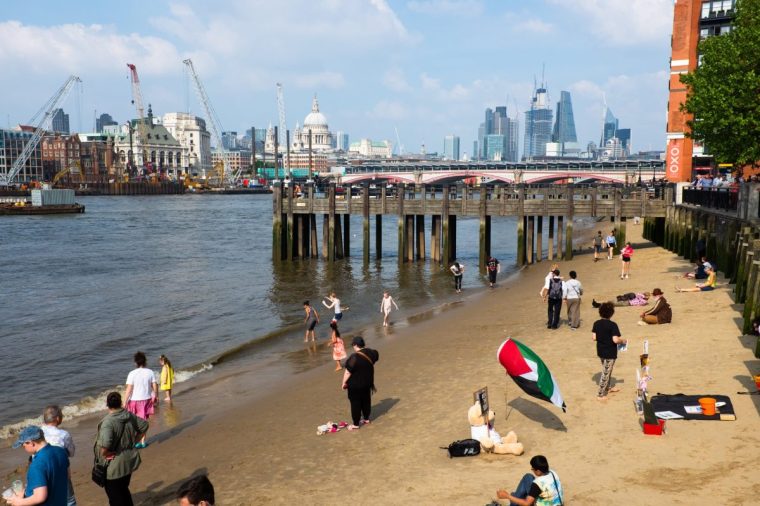 People gathering in the river Thames in South Bank in London, United Kingdom. The Thames may not be the first place that springs to mind when you fancy a swim, but with Londons most famous waterway now cleaner than its been for 150 years, wild swimming is on the up.