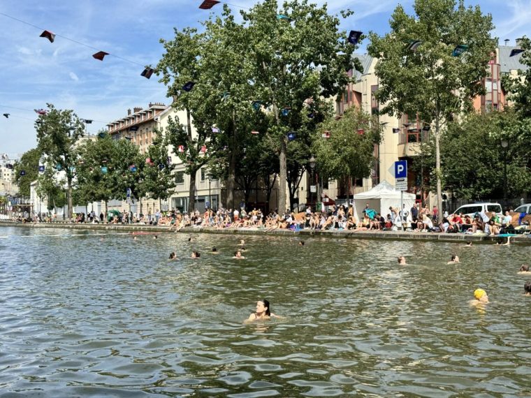 Paris, France - August 4, 2024 : People swimming at the open Bassin des Recollets in the Canal Saint-Martin on the Right Bank on a sunny summer day in Paris, France