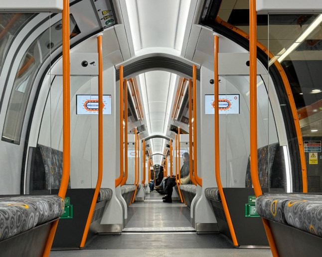 A view inside a new Glasgow Subway carriage with passengers sitting on the background.