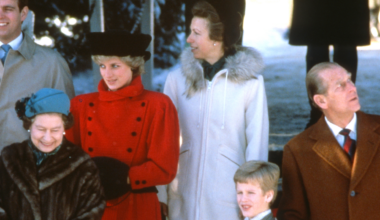 Queen Elizabeth in a fur coat, Princess Diana in a red coat, Princess Anne in a white coat and Prince Philip looking up to the side outside church at Christmas