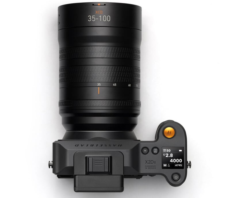 Top view of a Hasselblad X2D 100C camera with a large XCD 35-100mm lens attached, showing the control dials, display screen, and branding details.
