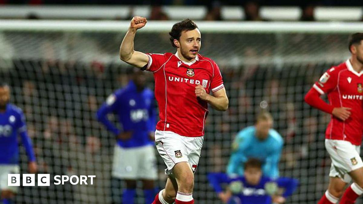 Wrexham midfielder Ollie Rathbone celebrates with clenched fist in the air