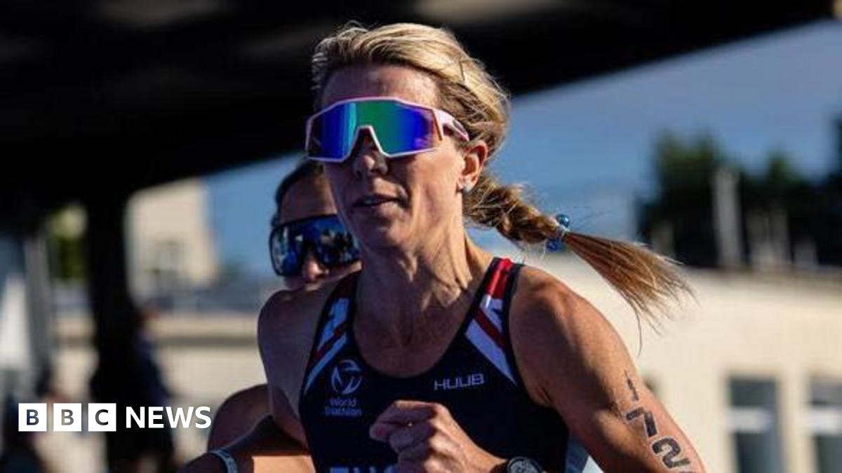 Zoe Tucker competing with a blue GBR running vest, the number 1720 on her arm, and a stadium of spectators behind her.
