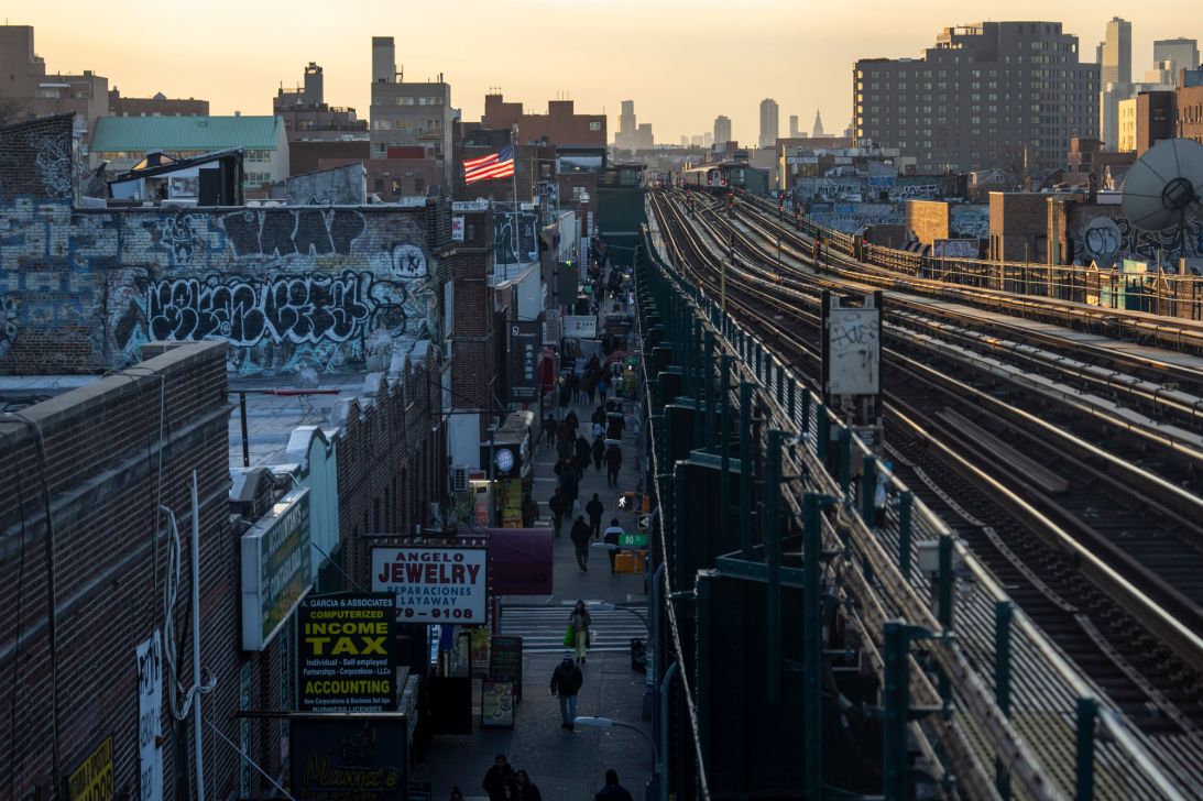 An American flag is seen on a rooftop as people walk on a street on Monday, December 22, 2025, in Queens.