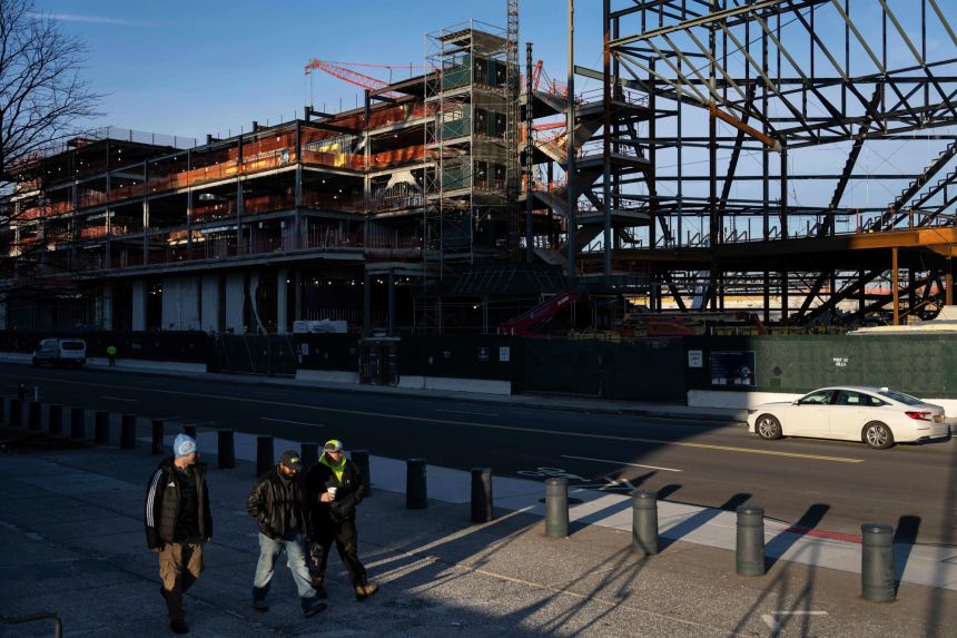 Construction workers walk past an affordable housing development in Willets Point in Queens on Monday, December 22, 2025.