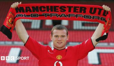 Wayne Rooney holds up a Manchester United scarf after joining the club