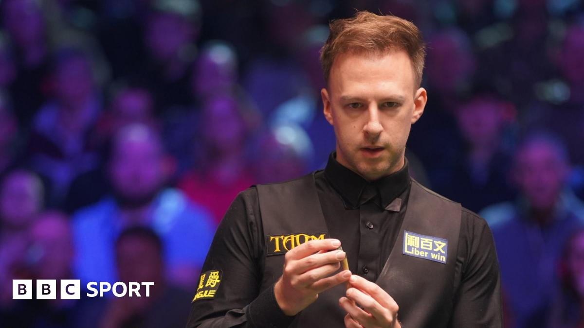 Judd Trump chalking his cue