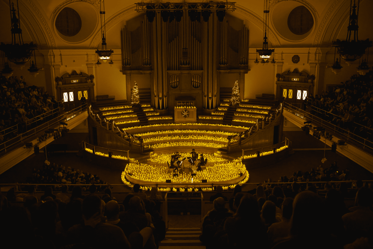 A string quartet performing on stage at a Christmas Candlelight concert at Central Hall Westminster