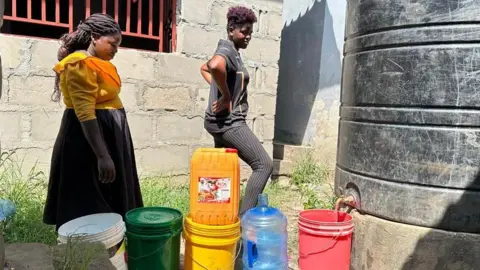 BBC Dar es Salaam queue to fetch water from a tank