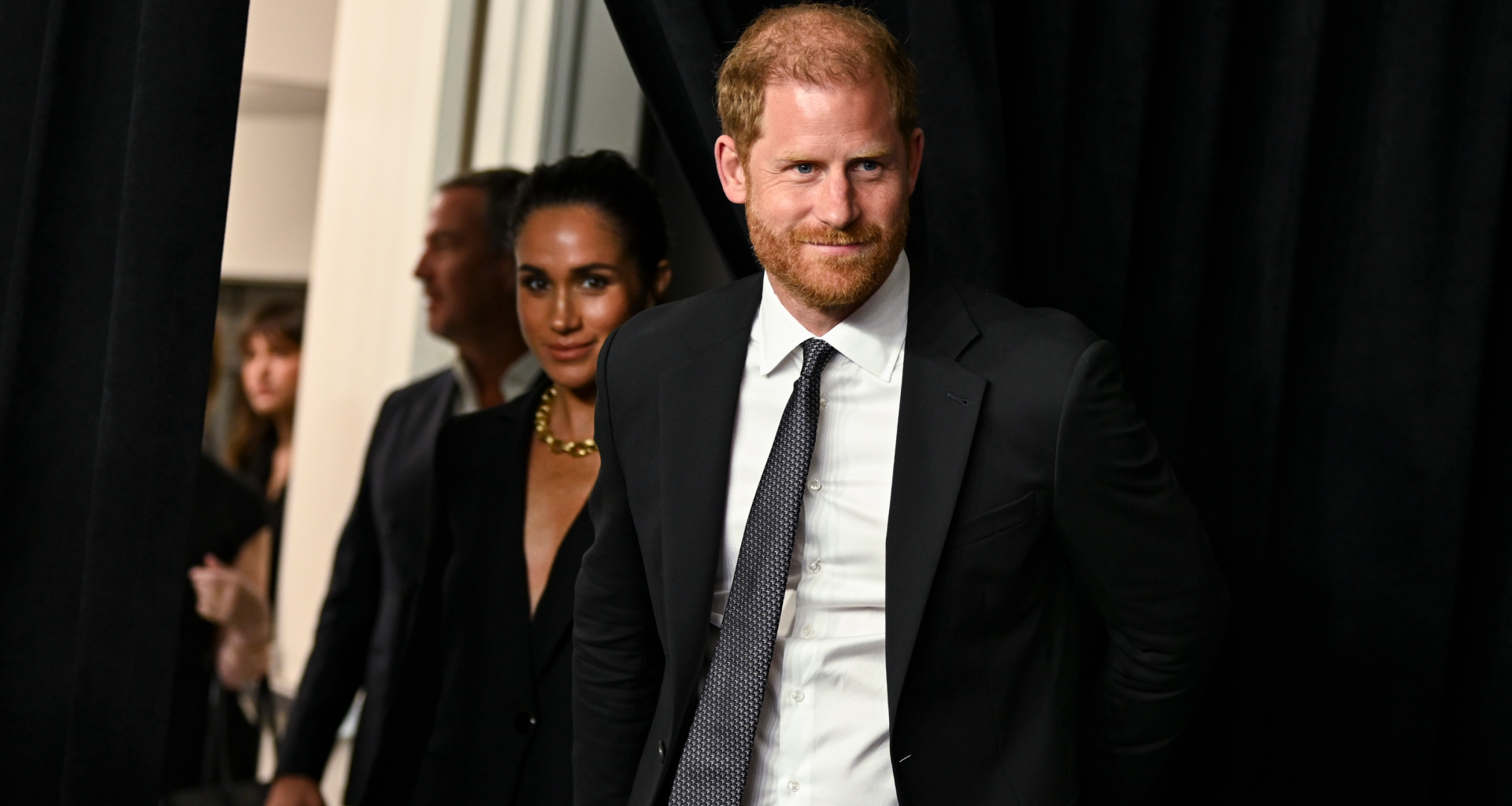 Meghan Markle and Prince harry wearing black suits