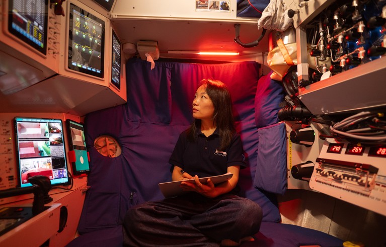 Portrait of Mengran Du, sitting and taking notes in a submersible.