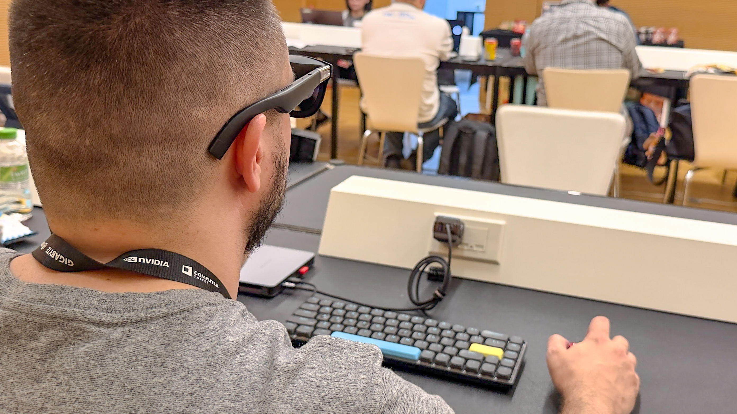 A person working on a mini PC with AR glasses at Computex in Taiwan