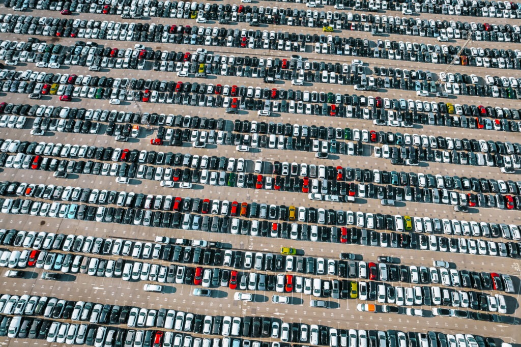 Aerial view of the stock of a large number of cars parked with order outside of an automobile company.