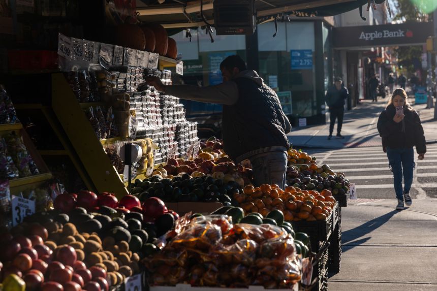 A man stacks fruit at a grocery store on November 6, 2025, in Brooklyn.