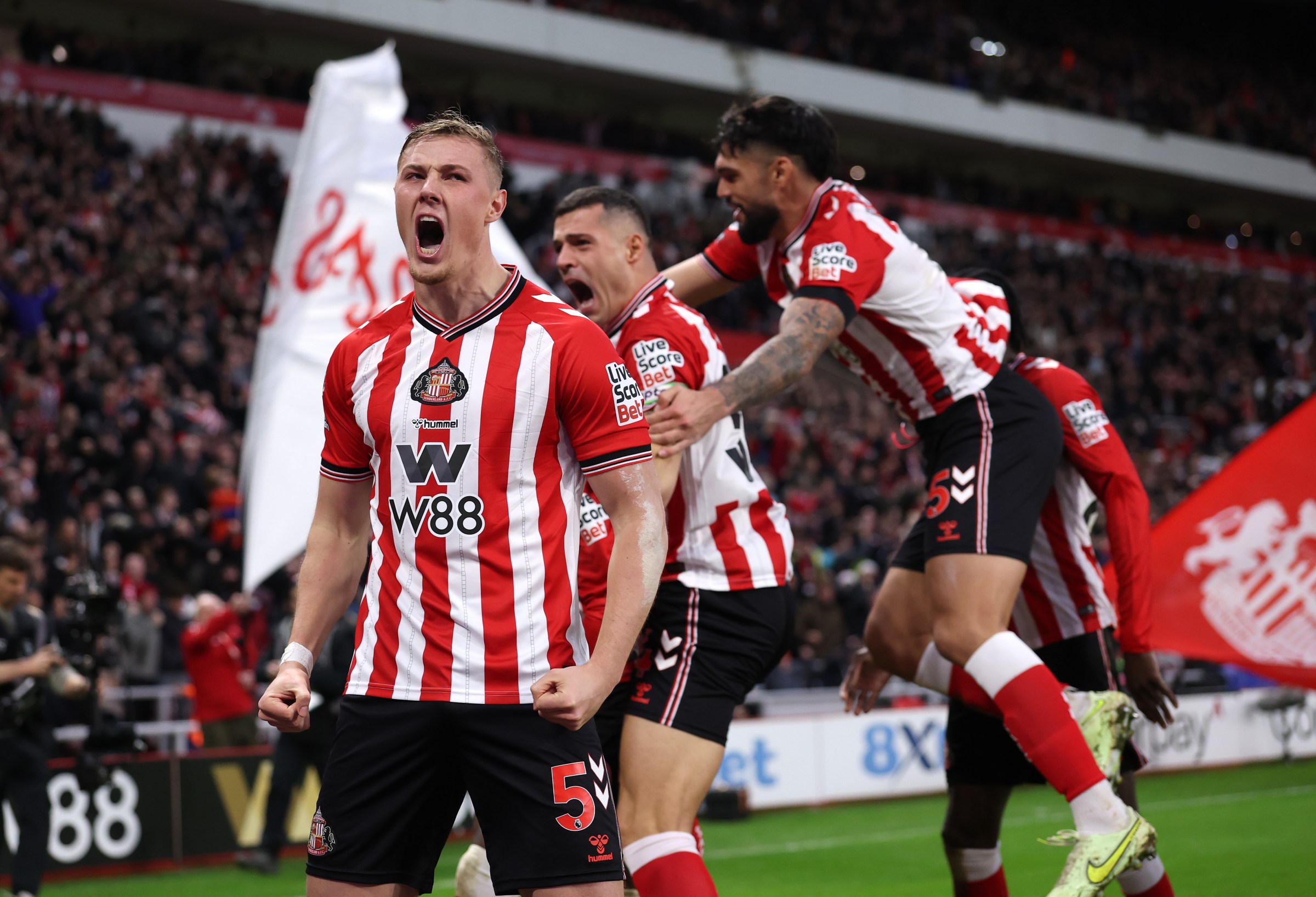 SUNDERLAND, ENGLAND - DECEMBER 14: Daniel Ballard of Sunderland celebrates the teams first goal, an own goal, conceded by Nick Woltemade of Newcastle United (not pictured) during the Premier League match between Sunderland and Newcastle United at Stadium of Light on December 14, 2025 in Sunderland, England. (Photo by Carl Recine/Getty Images)