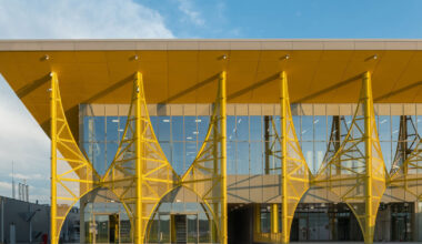 yellow metal arches frame airport’s terminal extension in romania