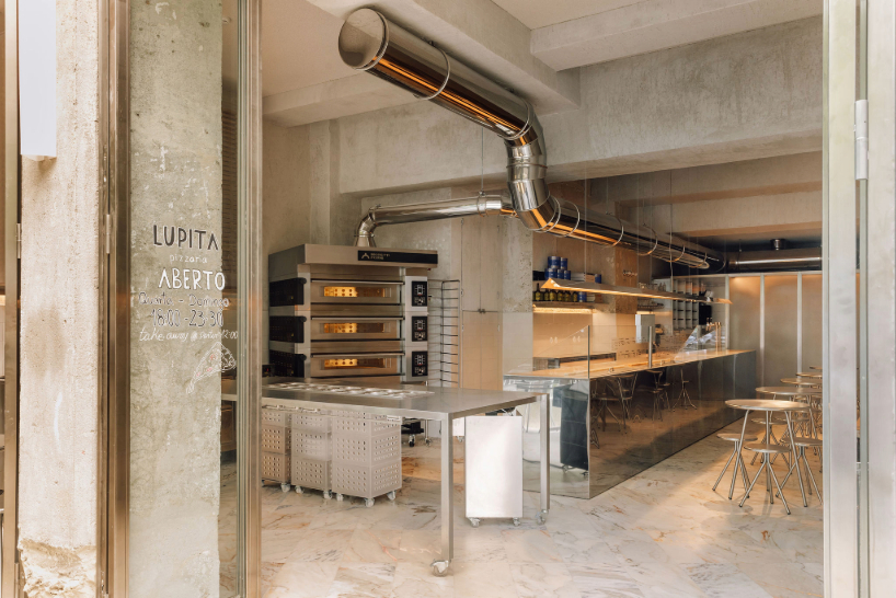 reflective steel interiors and open facade bring lisbon’s street activity into pizza restaurant
