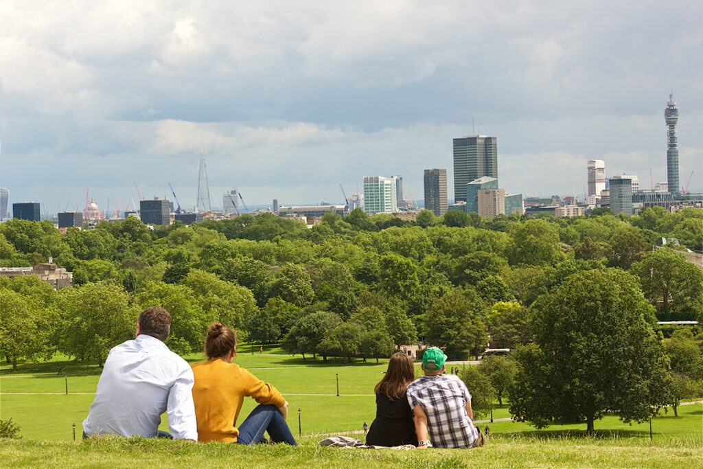 People enjoying the clear view of central London and Hampstead from the summit of Primrose Hill