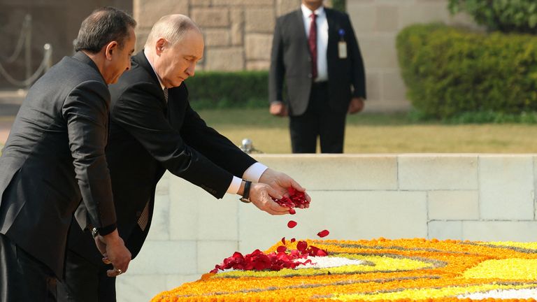 Mr Putin scatters rose petals at the Mahatma Gandhi memorial in New Delhi. Pic: Reuters