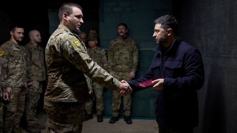 Ukraine's President Volodymyr Zelenskiy awards a Ukrainian service member, as he visits a frontline position, amid Russia's attack on Ukraine. Pic: Reuters