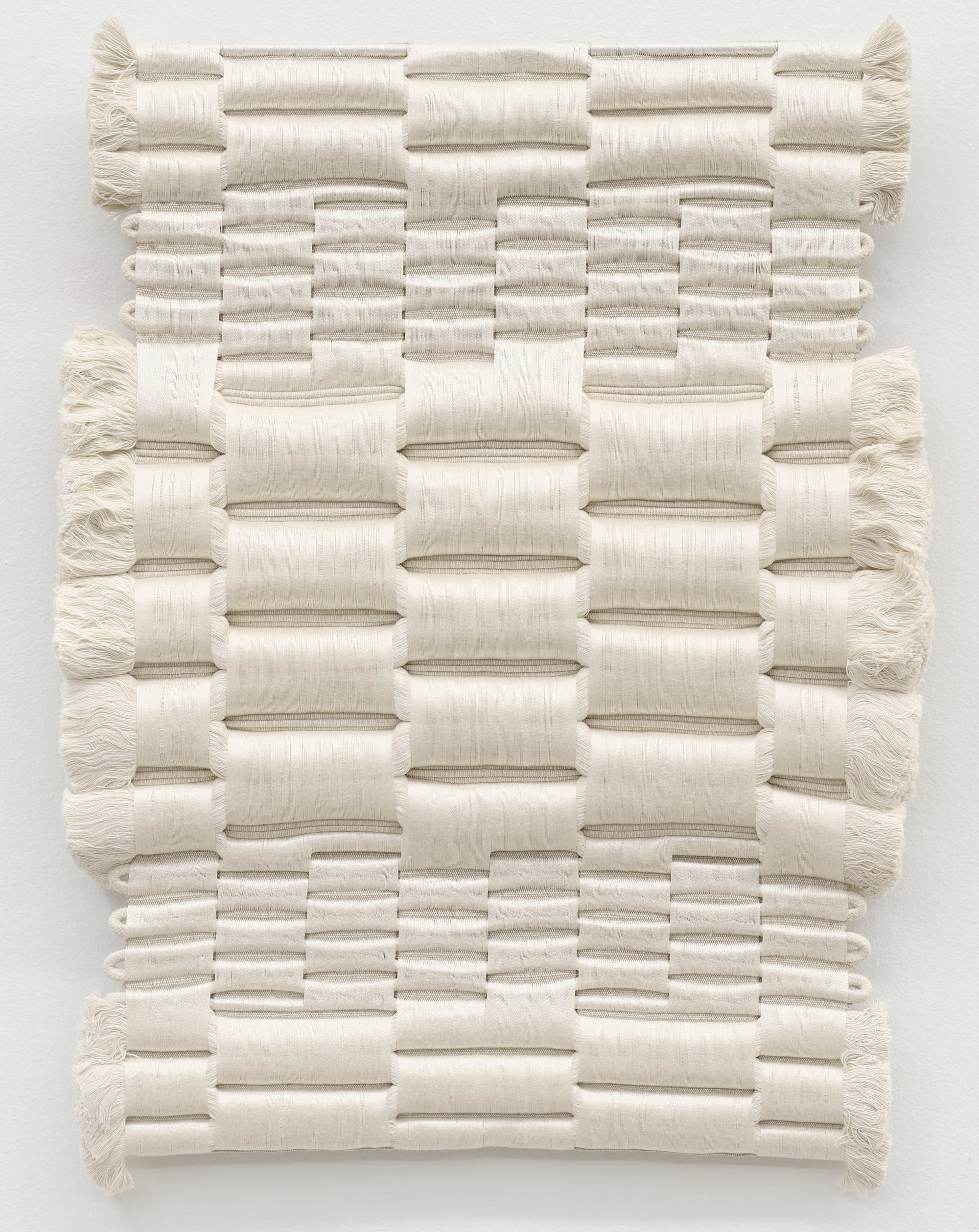 An all-white weaving by Molly Haynes with varying textures of thread